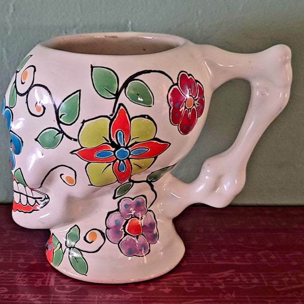 This skull shaped mug has a traditional Day of the Dead hand-painted design with a bone handle perfect to gets your bones moving in the morning.
