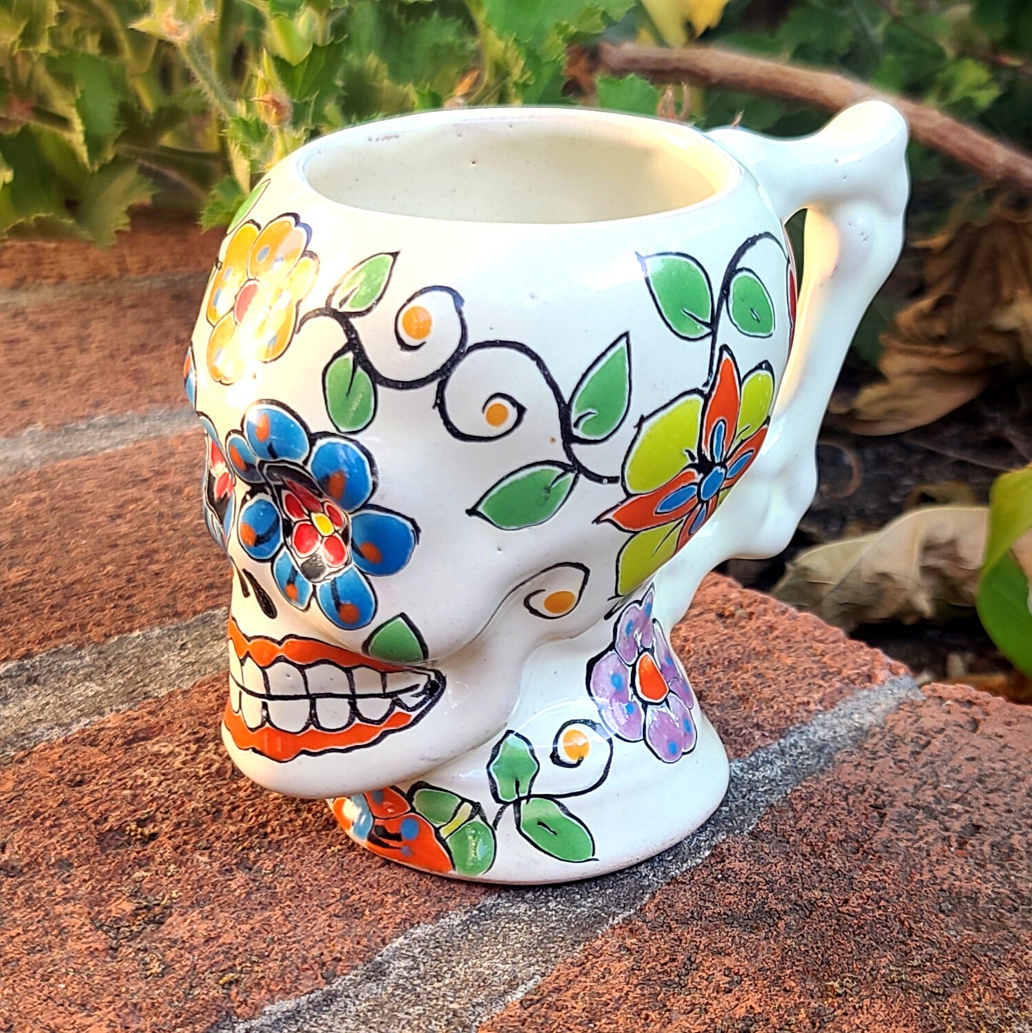 This skull shaped mug has a traditional Day of the Dead hand-painted design with a bone handle perfect to gets your bones moving in the morning.  